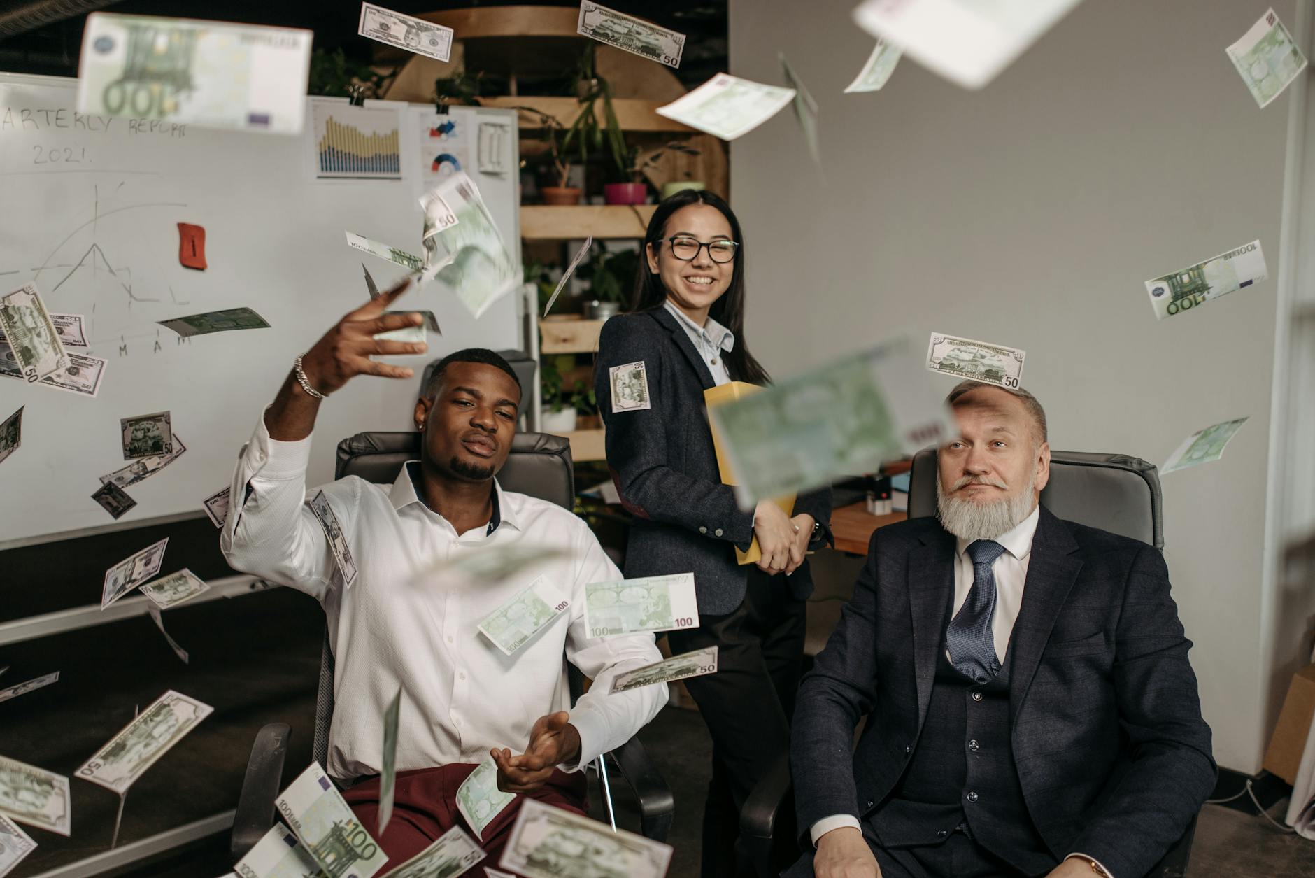 paper money falling around the people in business attire in the office