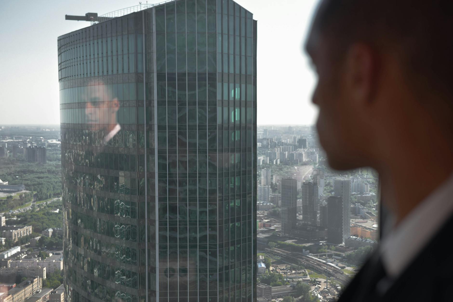 a reflection of a man on a glass window looking at the view